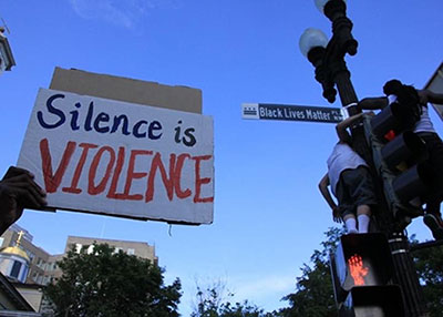 Silence is Violence protest sign near Black Lives Matter street sign