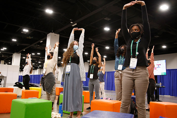 people in expo hall wellness center doing stretching exercises