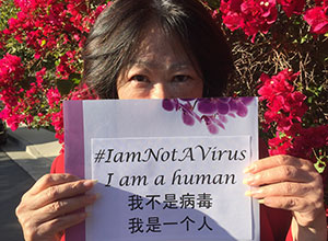 Elena Ong holding #IamNotAVirus I am a human sign