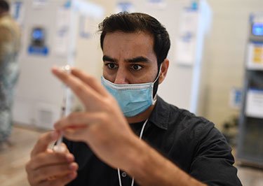 man looking at syringe