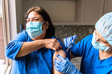 Masked patient receiving vaccination