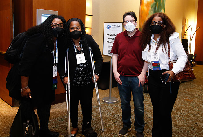 Four attendees at the Council on Affiliates reception pose for the camera. 