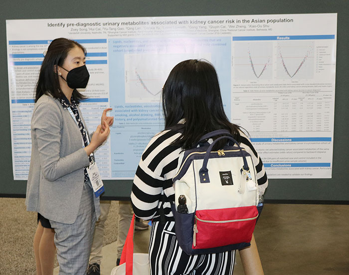 A poster presenter explains her research to another attendee. 