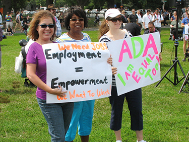 People hold signs supporting Americans with Disabilities Act