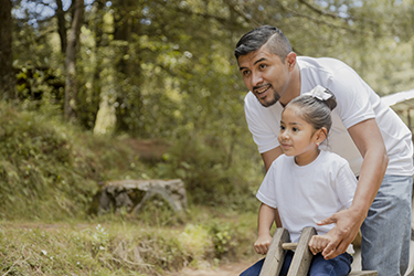 Man plays with his daughter in a park