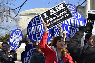 Women uphold abortion rights signs  at a protest