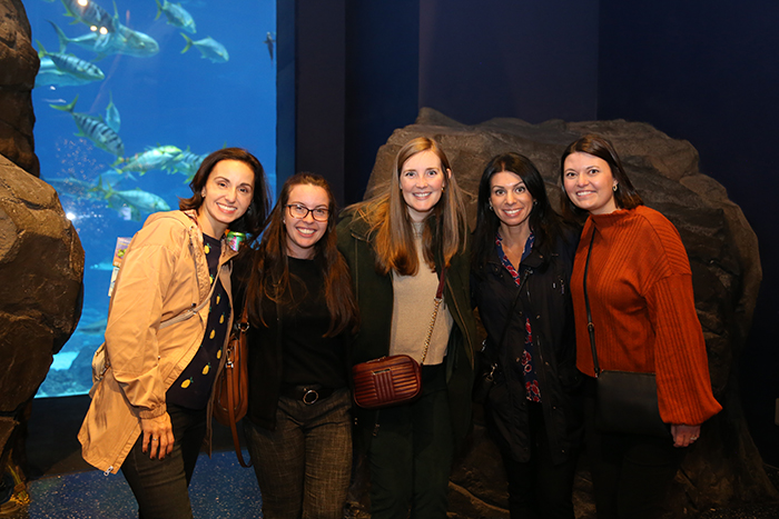 Five young women lean into each other and smile for the camera. 