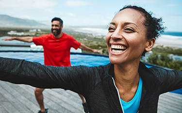 Man and woman smile as they do stretching exercises