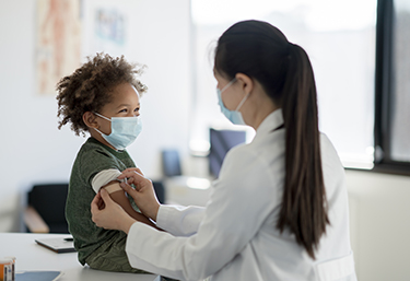 A boy get vaccinated by a nurse