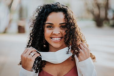 Woman smiling with mask pulled away from face