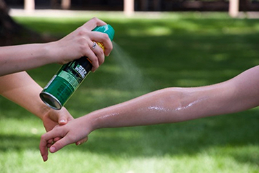 Bug spray gets applied to a person's arm 