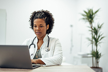 Woman works at a desk using a laptop