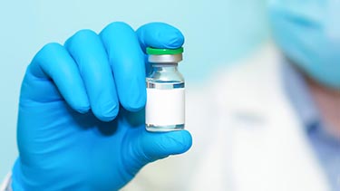 Researcher holds up a vial