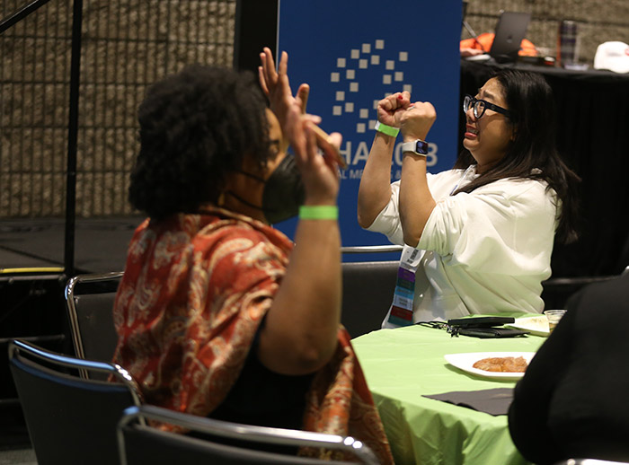 Chris Chanyasulkit holds her arms and clenched fists up, as if to say "I hope that's the right trivia answer!" 