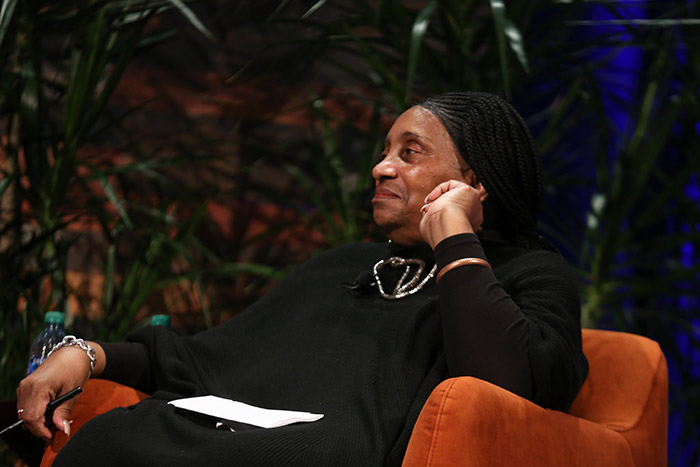 New APHA President Ella Greene Moton sits in a comfy orange chair and smiles while listening to others. 