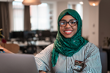 Woman wearing head scarf smiles at camera