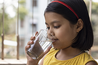 A girl drinks a glass of water