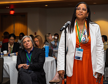 An attendee asks a question in front of a microphone at Policy Action Institute event