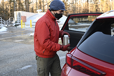 An epidemiologist carries a wastewater sample to be tested for COVID-19