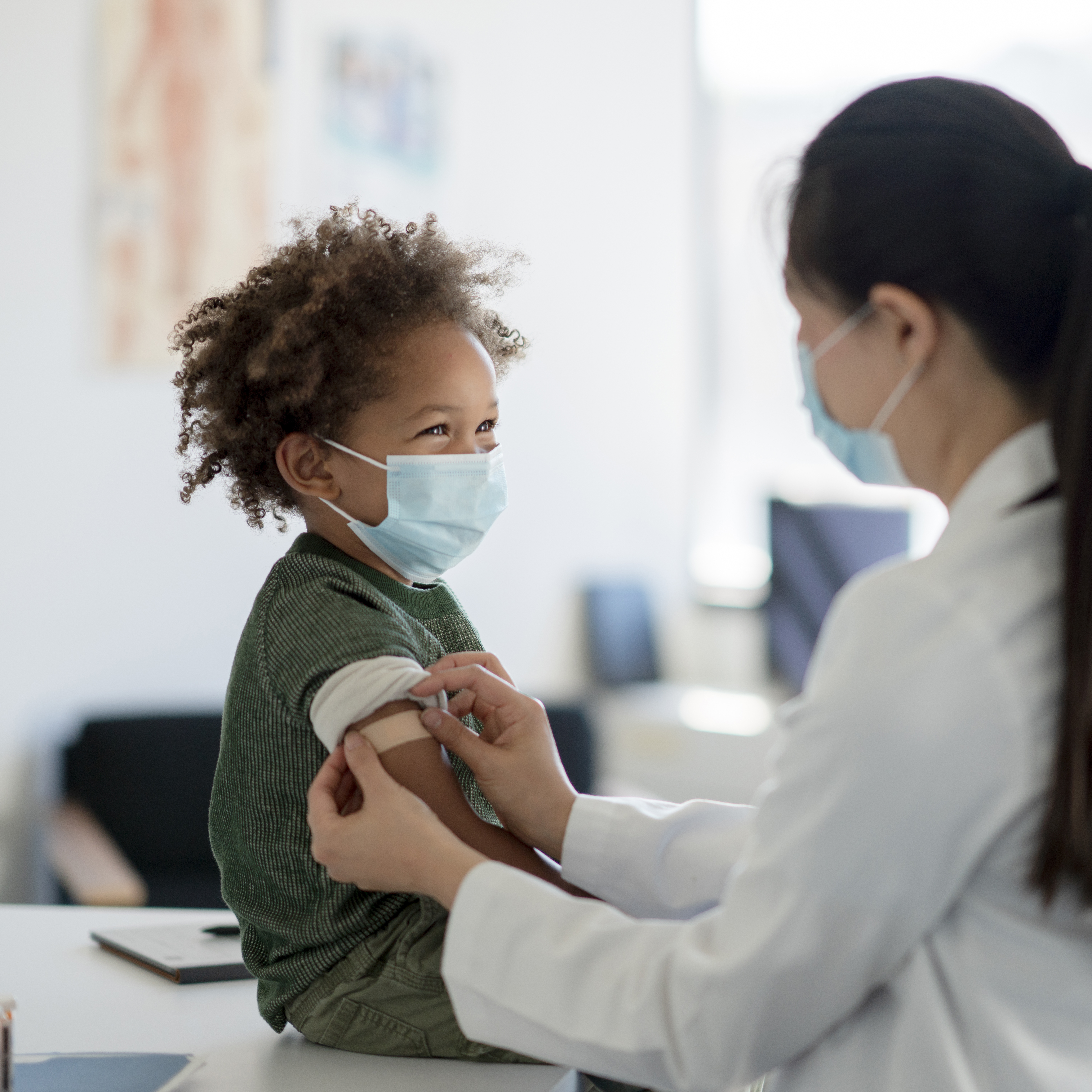 Boy receives a vaccination from a nurse