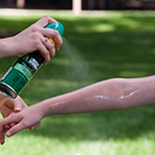 Bug spray gets applied to a person's arm