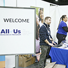 A person works at the booth of the All of Us Research Program at APHA's Annual Meeting
