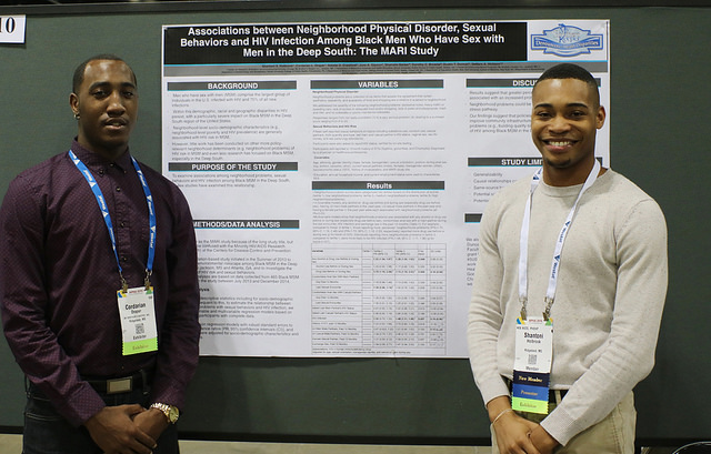 men pose with public health research poster